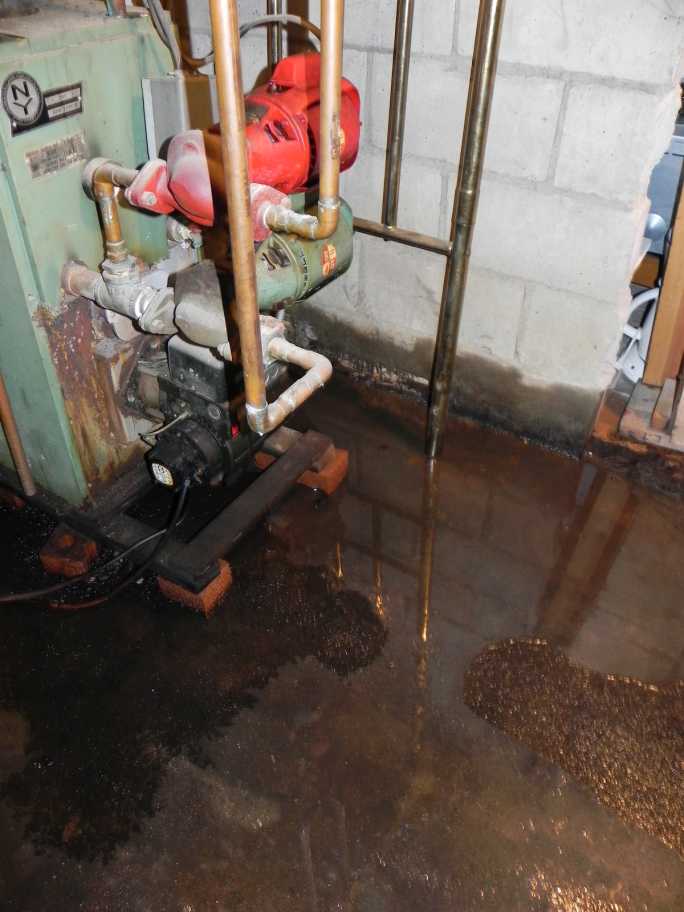 Staining on foundation walls with free oil pooling on the floor. An underground oil tank was located outside the foundation wall.