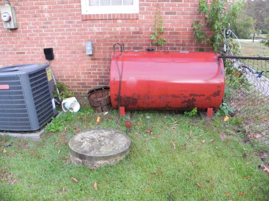 Underground tank located between the aboveground tank that replaced it and a water supply well.